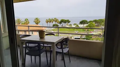 a table and chairs on a balcony with a view of the ocean at Nice Bel Appartement Vue Mer climatisé avec Grande Terrasse in Nice