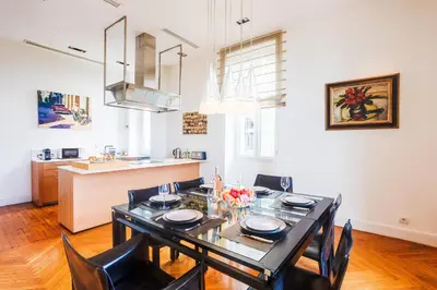 a dining room with a black table and chairs at PALAIS ALBERT 1ER AP4292 By Riviera Holiday Homes in Nice