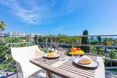 a wooden table with food on top of a balcony at PALAIS ALBERT 1ER AP4292 By Riviera Holiday Homes in Nice