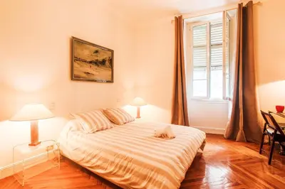 a bedroom with a bed with a cat laying on it at PALAIS ALBERT 1ER AP4292 By Riviera Holiday Homes in Nice