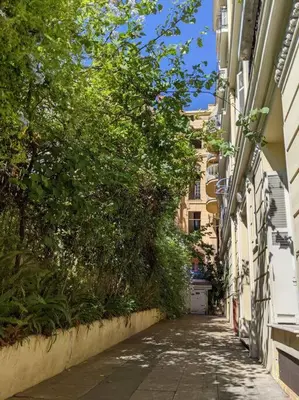 an empty alley between two buildings with trees at Amazing 2-bedroom apartment in Nice near the beach in Nice
