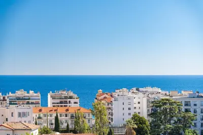 a group of buildings in front of the ocean at Nice Renting - CAMBRAI - Luxurious Sea View Terrasse - King Bed - Parking - AC - fully equipped in Nice