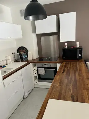 a kitchen with white cabinets and a black microwave at Ninon in Nice