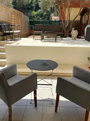 a patio with two chairs and a table and benches at Ninon in Nice
