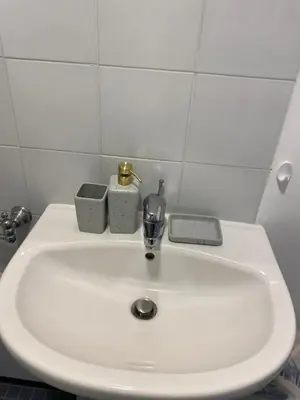 a white bathroom sink with a soap dispenser on it at The Grand Riviera Apartments Nice - Top Choice in Nice in Nice