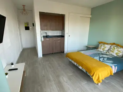 a small bedroom with a bed and a kitchen at Coquet logement front de mer in Cagnes-sur-Mer
