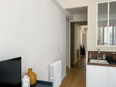 a living room with a tv and a kitchen at Mediterranee - un trois pièces à deux pas de la plage in Nice