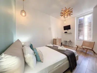 a bedroom with a large bed and a tv at Nestor&Jeeves - LE PIERLAS - Place Garibaldi - Very close Old Town in Nice
