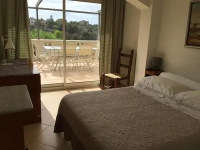 a bedroom with a bed and a view of a patio at Villa Paradiso, logement avec piscine, Nice Nord in Nice