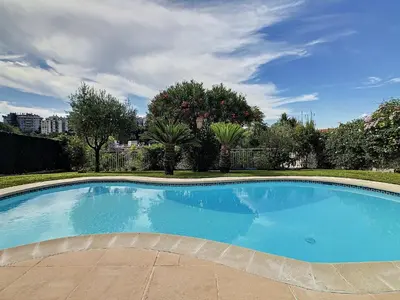 a large blue swimming pool in a yard at Villa Paradiso, logement avec piscine, Nice Nord in Nice