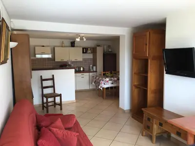 a living room with a red couch and a kitchen at Villa Paradiso, logement avec piscine, Nice Nord in Nice