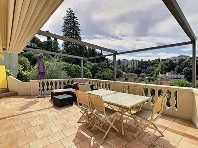 a patio with a table and chairs on a balcony at Villa Paradiso, logement avec piscine, Nice Nord in Nice
