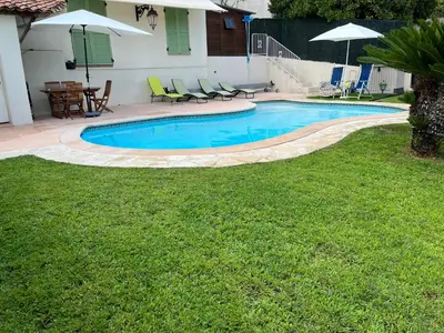a swimming pool in a yard with chairs and a table at Villa Paradiso, logement avec piscine, Nice Nord in Nice