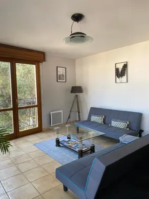 a living room with a blue couch and a table at Appartement 02 Vue Panoramique -WIFI- Parking privé -NICE in Nice