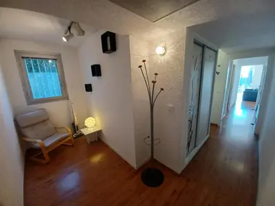 a living room with a chair and a plant at L'Eau-Dyssée, clim, parking privé, jardin in Saint-Laurent-du-Var