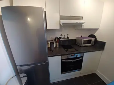 a small kitchen with a refrigerator and a microwave at L'Eau-Dyssée, clim, parking privé, jardin in Saint-Laurent-du-Var