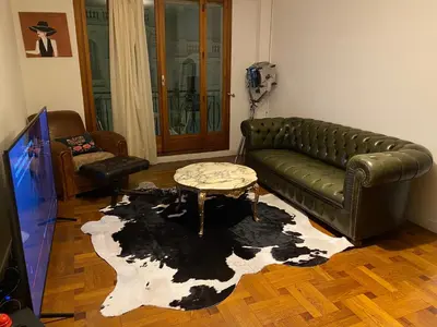 a living room with a leather couch and a table at I Love you Berry Berry Much! in Nice