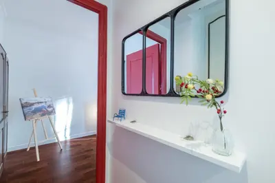 a bathroom with a mirror and a vase with flowers on a shelf at LE 323 PROM - BEACHFRONT - PARKING - NEAR TRAM &SUPERMARKET - AC - washing machine in Nice