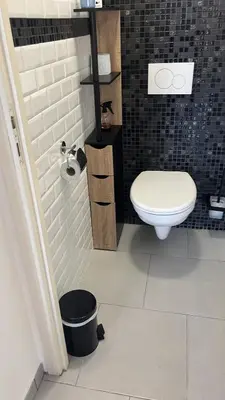 a bathroom with a toilet and a black tiled wall at Beau 2P, très équipé, localisation parfaite/AC in Villefranche-sur-Mer