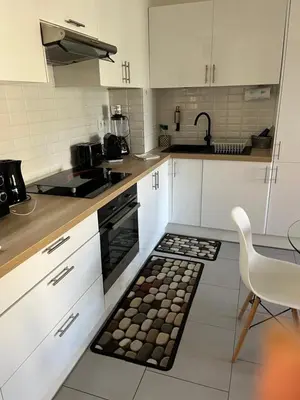 a kitchen with white cabinets and a table and a rug at Beau 2P, très équipé, localisation parfaite/AC in Villefranche-sur-Mer