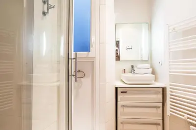 a white bathroom with a sink and a shower at MASSENA AP4312 By Riviera Holiday Homes in Nice