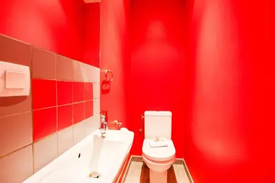 a red bathroom with a toilet and a bath tub at MASSENA AP4312 By Riviera Holiday Homes in Nice