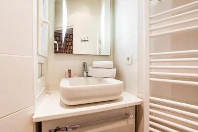 a white bathroom with a sink and a mirror at MASSENA AP4312 By Riviera Holiday Homes in Nice