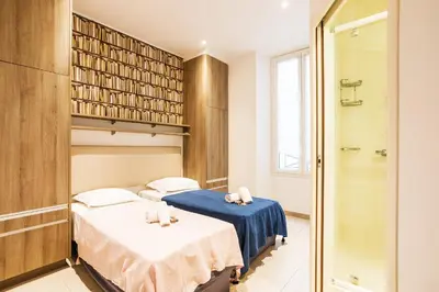 two beds in a room with a shower at MASSENA AP4312 By Riviera Holiday Homes in Nice
