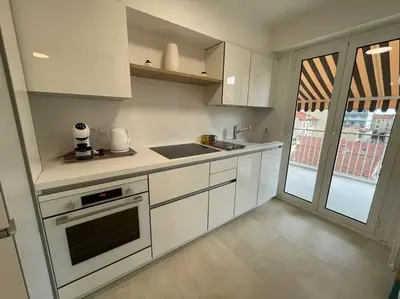 a white kitchen with a sink and a stove at PALAIS ROYAL - Appartement tout confort in Nice