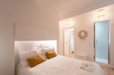 a white bedroom with a large white bed with two pillows at Old Town Nice Renovated 2BR Near Beaches & Cours Saleya in Nice