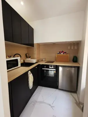 a kitchen with black cabinets and a microwave at Proche mer, vieille ville. Luxueux appartement in Villefranche-sur-Mer