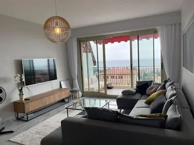 a living room with a couch and a large window at Exceptional sea view, tennis, parking, WiFi in Nice