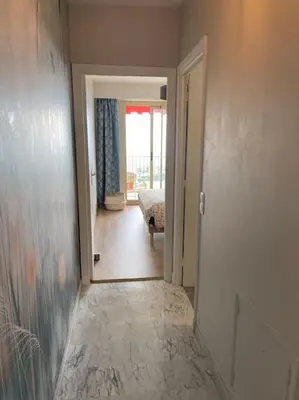 a hallway with a room with a bed and a door at Exceptional sea view, tennis, parking, WiFi in Nice