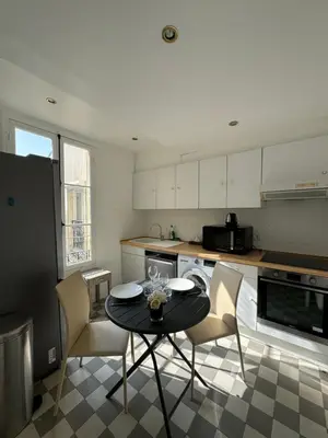 a kitchen with a table and chairs in a kitchen at Aston - Appartement Centre Ville Massena in Nice