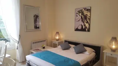 a bedroom with a bed and two lamps and a window at Aston - Appartement Centre Ville Massena in Nice