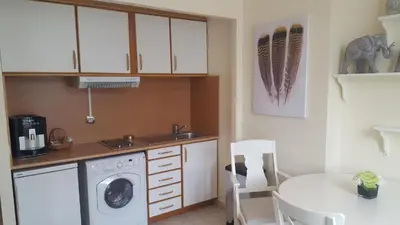 a kitchen with a washing machine and a table at Aston - Appartement Centre Ville Massena in Nice