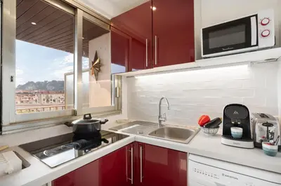 a kitchen with red cabinets and a sink and a window at BLUE LIGHT TERRACE - Nice Port in Nice