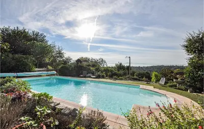 a swimming pool in a garden with the sun in the sky at Nice Home In Saint-Jeannet in Saint-Jeannet