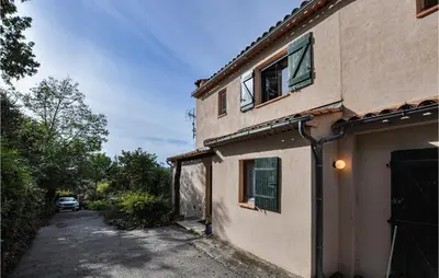a house with a car parked next to a driveway at Nice Home In Saint-Jeannet in Saint-Jeannet