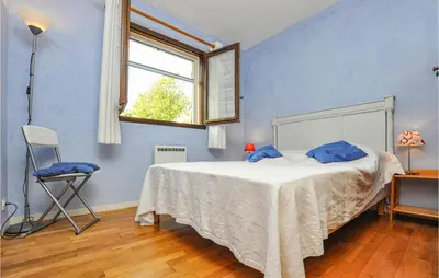 a bedroom with a bed and a window and a chair at Nice Home In Saint-Jeannet in Saint-Jeannet