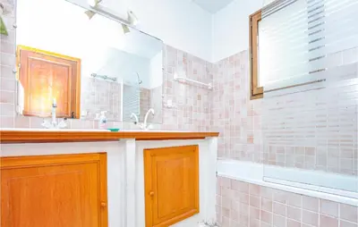 a bathroom with a sink and a tub and a mirror at Nice Home In Saint-Jeannet in Saint-Jeannet