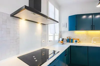 a kitchen with blue cabinets and a sink at COSY GARNIER AP4281 by Riviera Holiday Homes in Nice