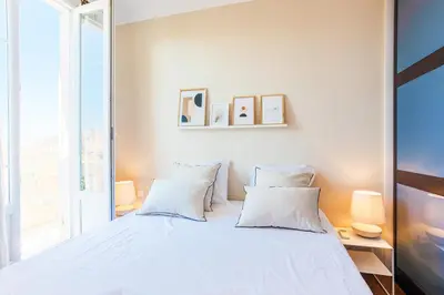 a bedroom with a large bed with white pillows at COSY GARNIER AP4281 by Riviera Holiday Homes in Nice