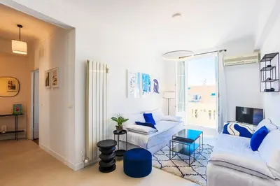 a living room with white furniture and a large window at COSY GARNIER AP4281 by Riviera Holiday Homes in Nice