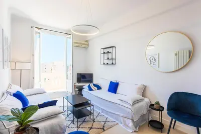 a living room with a couch and a mirror at COSY GARNIER AP4281 by Riviera Holiday Homes in Nice