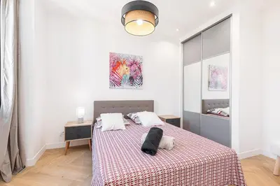 a bedroom with a bed with a red and white blanket at Magnifique appartement, Nice Centre Ville - Masséna in Nice