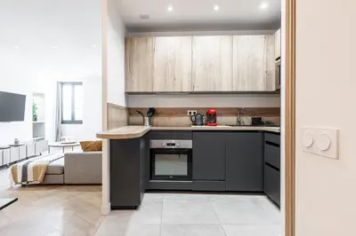 a kitchen with black counters and wooden cabinets at Magnifique appartement, Nice Centre Ville - Masséna in Nice