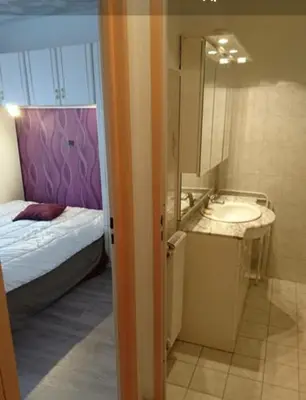 a bathroom with a sink and a bed and a mirror at Appartement Nice Promenade des Anglais pour 4 personnes in Nice