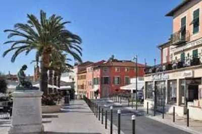 a city street with palm trees and buildings at 2P neuf au Coeur de St Jean Cap Ferrat in Saint-Jean-Cap-Ferrat