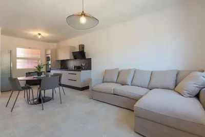 a living room with a couch and a table at 2P neuf au Coeur de St Jean Cap Ferrat in Saint-Jean-Cap-Ferrat